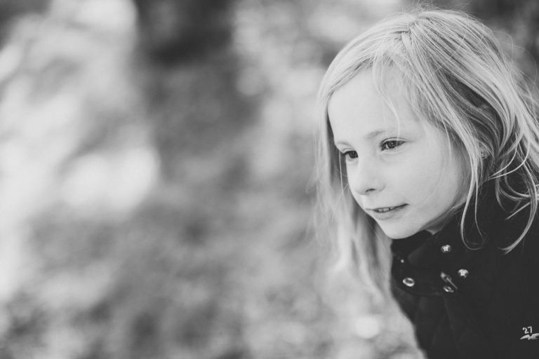 fint porträtt på liten nyfiken tjej svartvit bild familjefotografering barnfoto Fotograf Henrik Mill Västerås Sverige